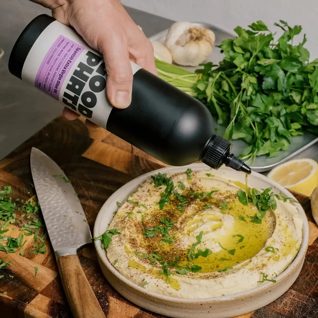 Good Phats Spanish Extra Virgin Olive Oil in a squeezy bottle drizzled over homemade hummus